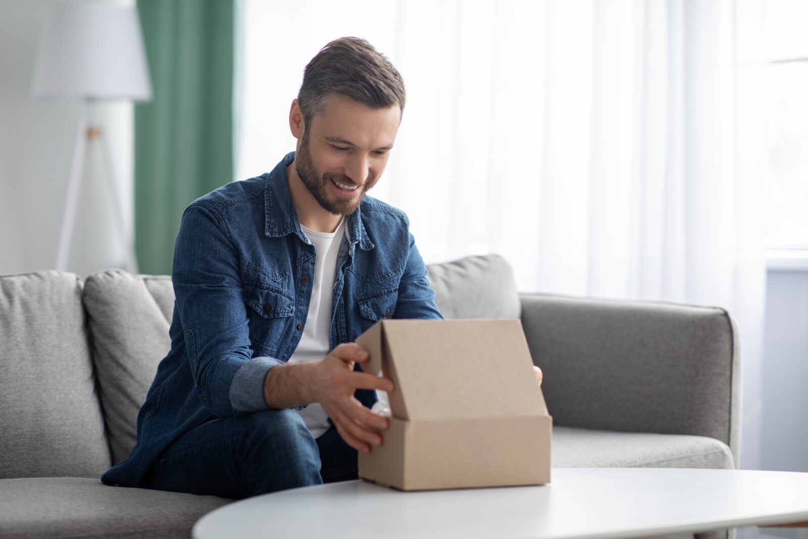 Happy man unpacking delivery box