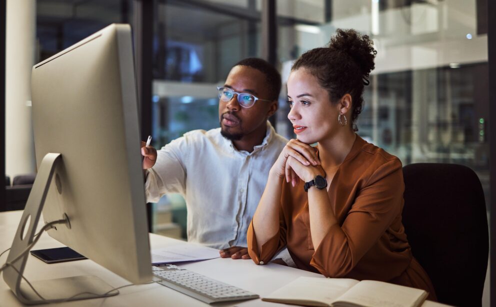 two people working on computer in an office