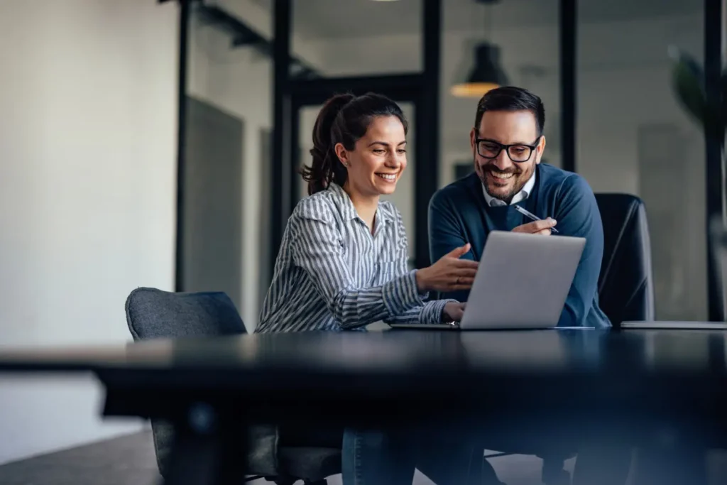 two people in an office looking at something online