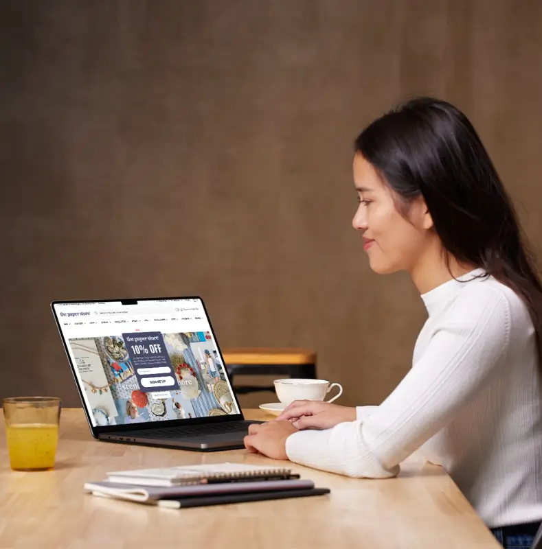 Woman viewing TPS website design mockup on laptop